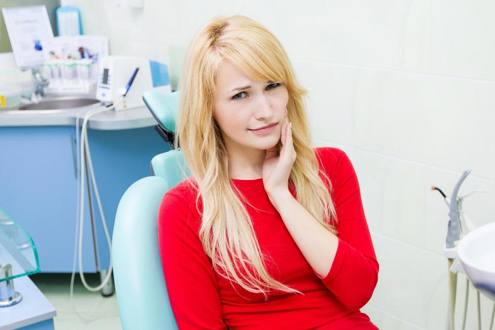woman in red with toothache | same day dental care farragut