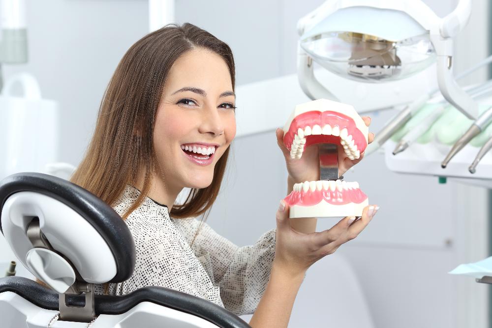 woman holding mouth model | dentist office near me