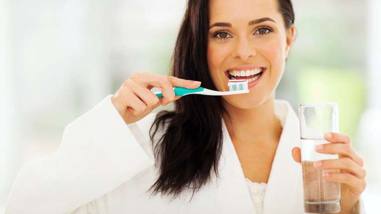 woman brushing her teeth in knoxville