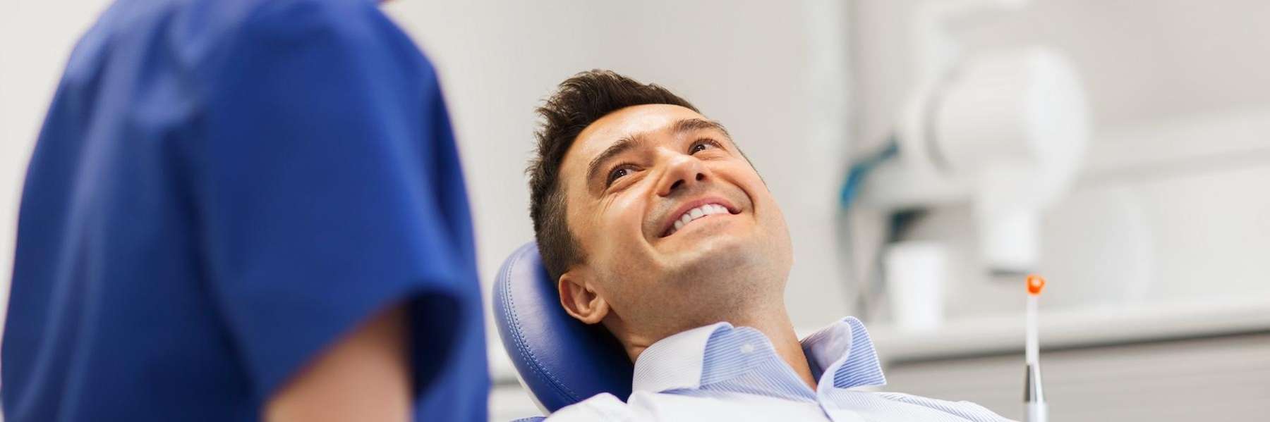 A smiling man talking to his dentist